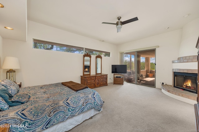 bedroom with carpet floors, a tiled fireplace, ceiling fan, and access to exterior