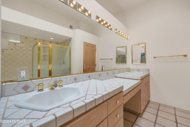 bathroom featuring tile patterned floors, a shower with door, and vanity