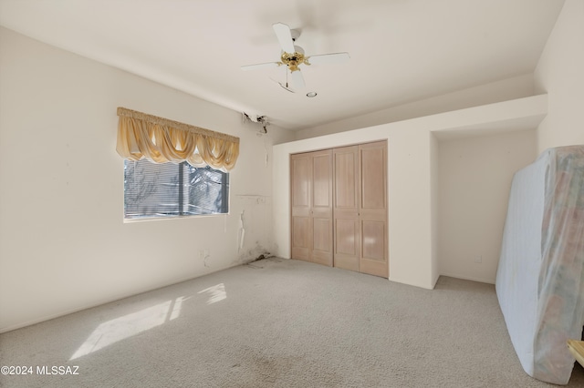 unfurnished bedroom featuring light carpet, ceiling fan, and a closet