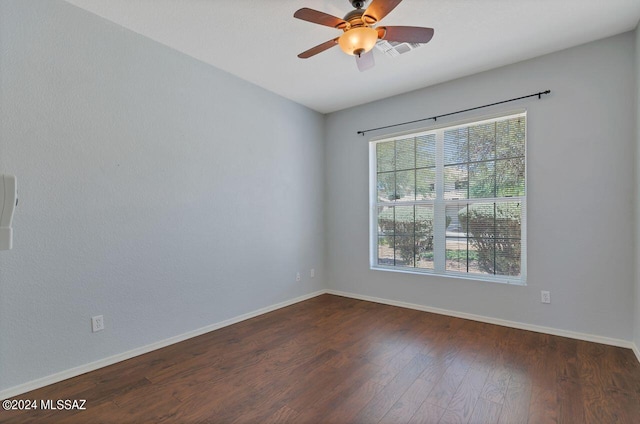 spare room with dark wood finished floors, baseboards, and a ceiling fan
