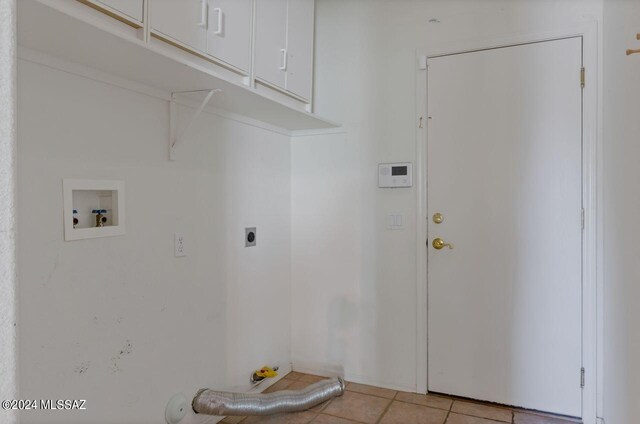 laundry room featuring washer hookup, electric dryer hookup, light tile patterned floors, and cabinets