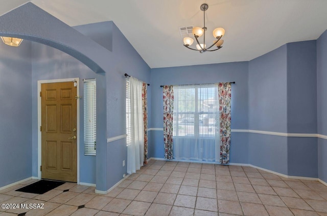 spare room with visible vents, arched walkways, a notable chandelier, and tile patterned flooring