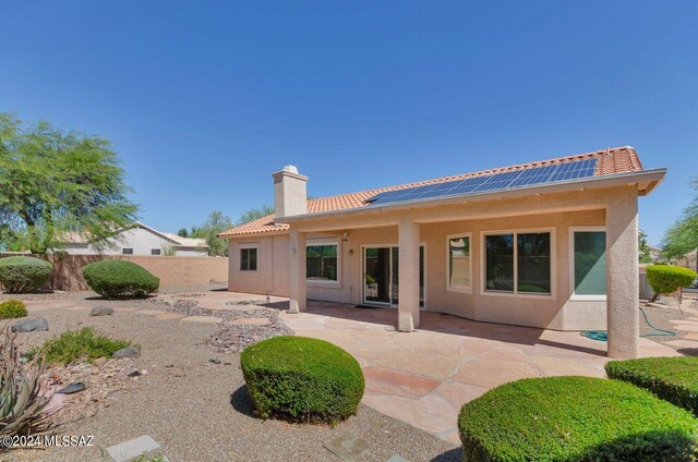 back of house featuring solar panels and a patio