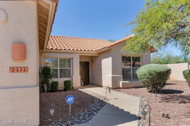 property entrance featuring stucco siding and a tile roof
