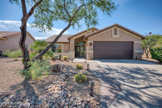 1892 E E Clf, Swallow Trail, Green Valley, AZ 85614 - view of front facade with an attached garage, concrete driveway, a tile roof, and stucco siding