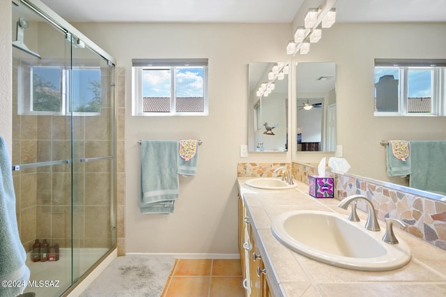 bathroom featuring a shower with door, vanity, tasteful backsplash, and tile patterned floors