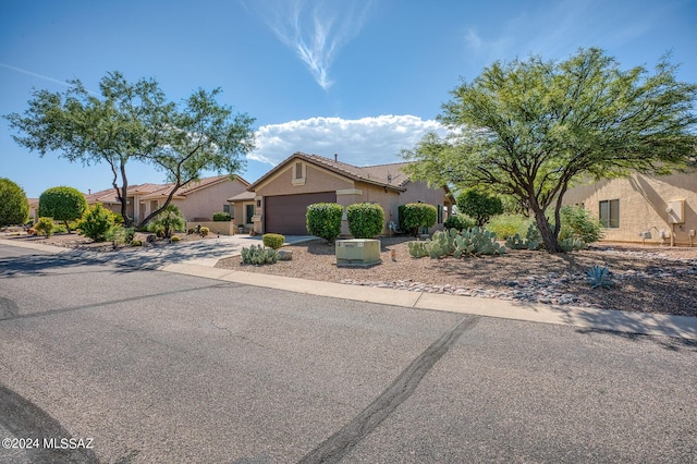 1892 E E Clf, Swallow Trail, Green Valley, AZ 85614 - view of front facade featuring an attached garage, stucco siding, and concrete driveway