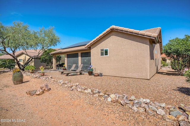 1892 E E Clf, Swallow Trail, Green Valley, AZ 85614 - rear view of house featuring a tiled roof, roof mounted solar panels, a patio area, and stucco siding