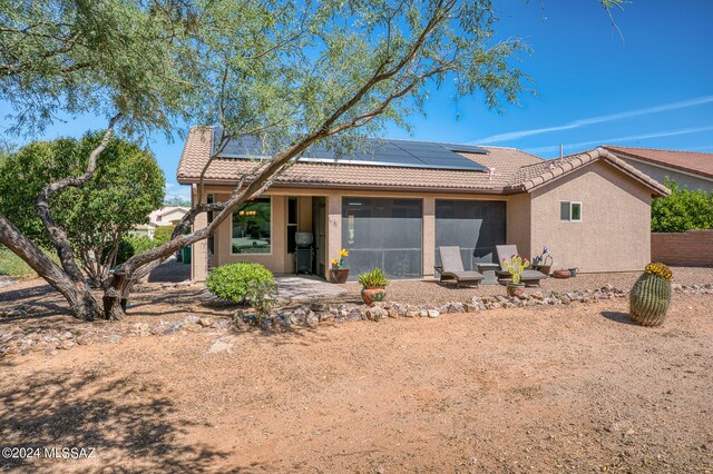 view of front of house featuring a patio and solar panels