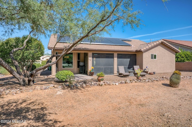1892 E E Clf, Swallow Trail, Green Valley, AZ 85614 - rear view of house featuring a chimney, a sunroom, solar panels, and a tile roof