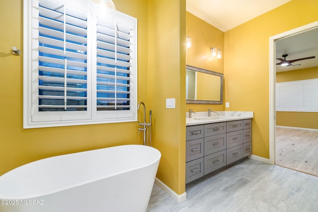 bathroom with ceiling fan, vanity, a bathing tub, and hardwood / wood-style floors