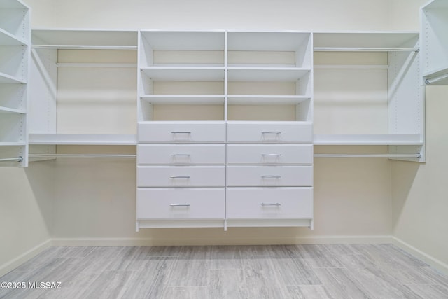 walk in closet with light wood-type flooring