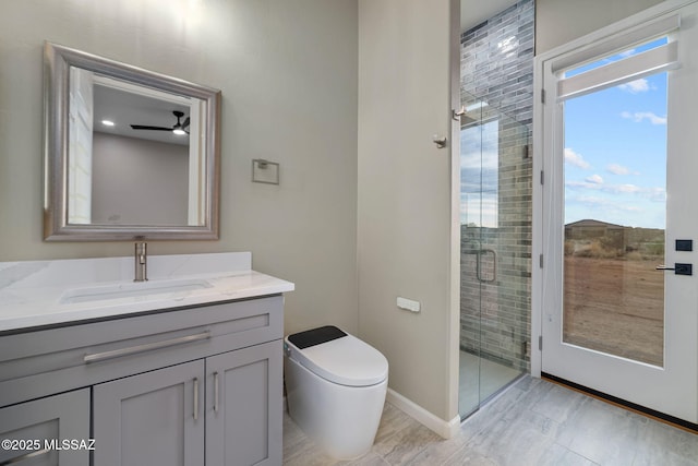 bathroom featuring toilet, vanity, and a shower with door