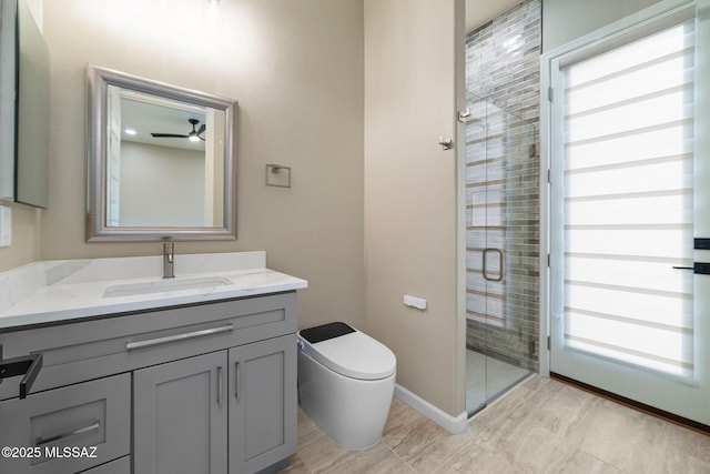 bathroom featuring an enclosed shower, vanity, toilet, and a healthy amount of sunlight