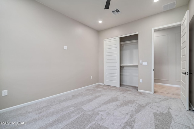 unfurnished bedroom with light carpet, a closet, and ceiling fan