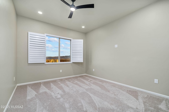 empty room featuring ceiling fan and light carpet