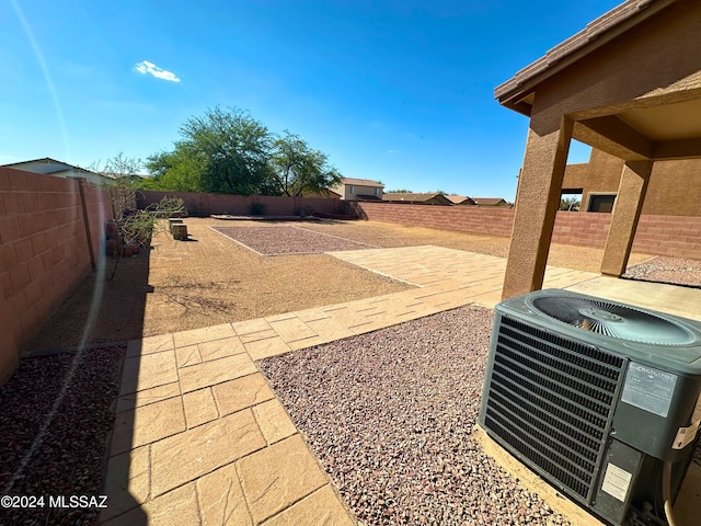 view of yard with central AC and a patio area