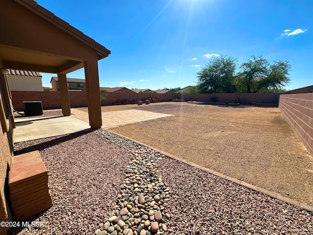 view of yard with cooling unit and a patio