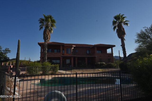 back of house featuring a community pool and a patio