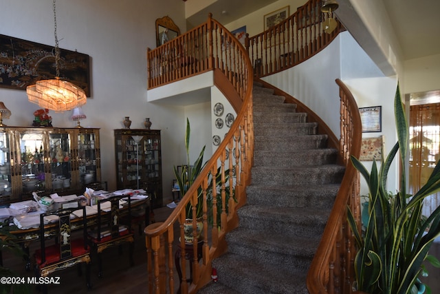 stairs with a notable chandelier and hardwood / wood-style flooring