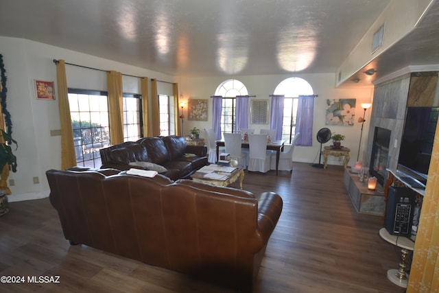 living room with a healthy amount of sunlight, a fireplace, and dark hardwood / wood-style flooring