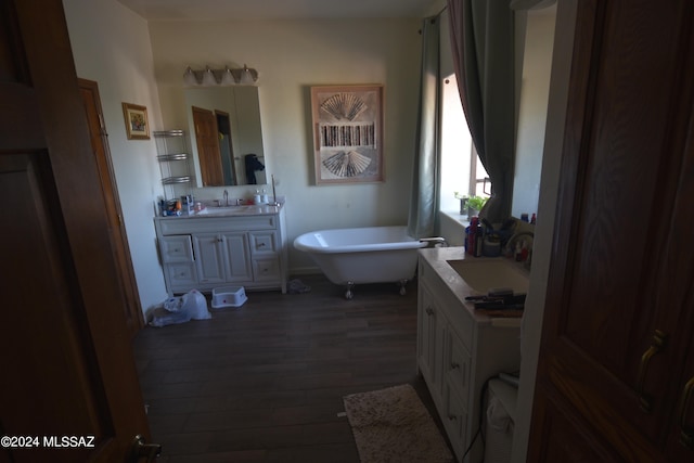 bathroom featuring vanity, hardwood / wood-style flooring, and a tub