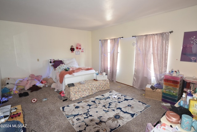 carpeted bedroom featuring multiple windows