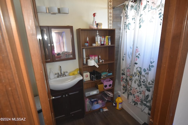 bathroom featuring wood-type flooring, vanity, and shower / tub combo with curtain