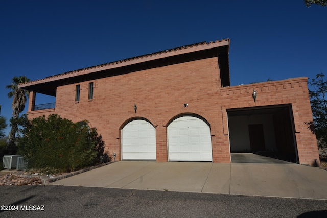 exterior space featuring central AC unit and a garage