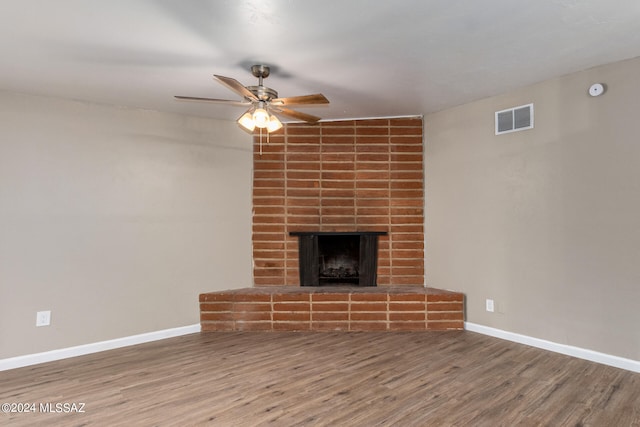 unfurnished living room with a fireplace, wood-type flooring, and ceiling fan