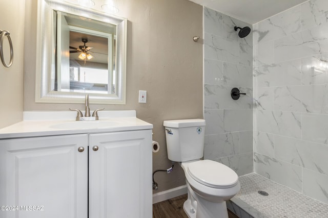 bathroom with vanity, hardwood / wood-style floors, toilet, and tiled shower