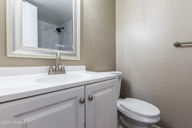 bathroom featuring vanity, toilet, and a shower