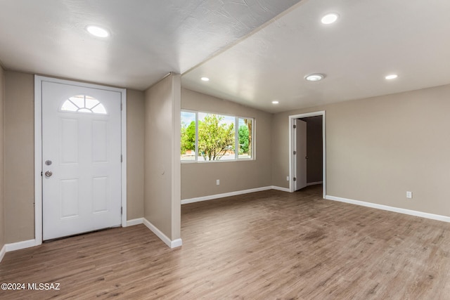 foyer entrance featuring vaulted ceiling and light wood-type flooring