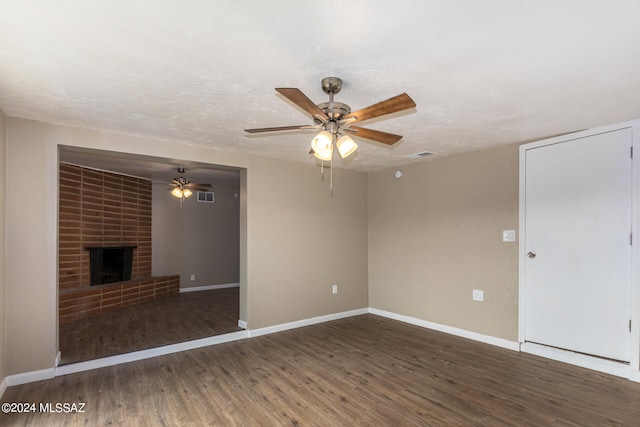 unfurnished living room with a textured ceiling, ceiling fan, a fireplace, and dark hardwood / wood-style flooring