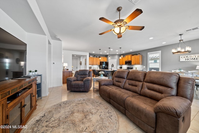 tiled living room featuring ceiling fan with notable chandelier