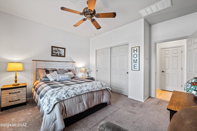 bedroom featuring ceiling fan, light colored carpet, and a closet