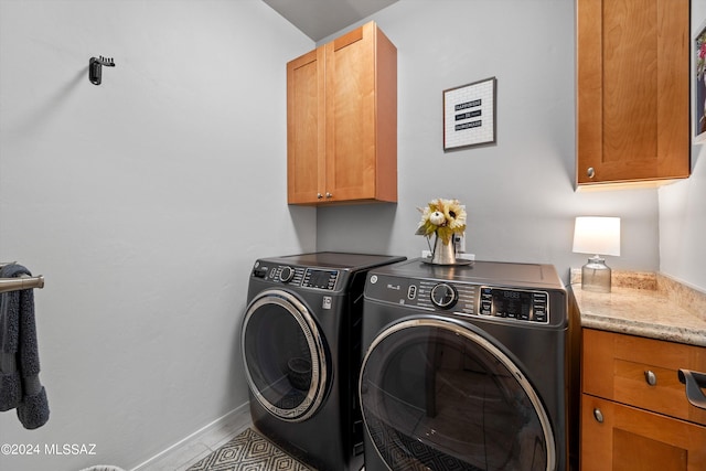 washroom featuring tile patterned flooring, independent washer and dryer, and cabinets