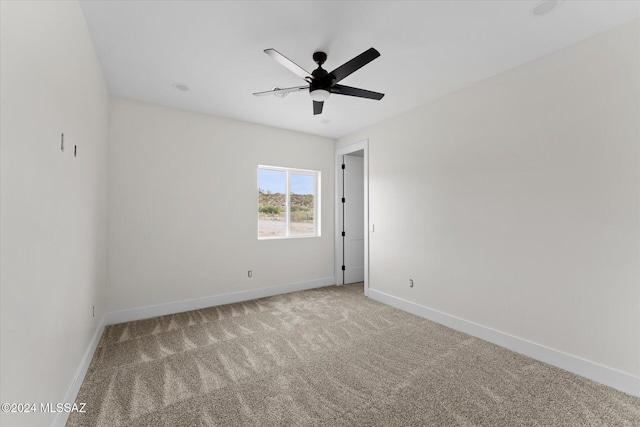 empty room featuring ceiling fan and light colored carpet