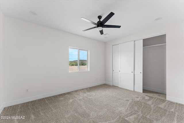 unfurnished bedroom with carpet floors, ceiling fan, and a closet