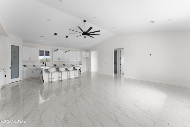 kitchen with a kitchen island, white cabinetry, a breakfast bar area, lofted ceiling, and ceiling fan