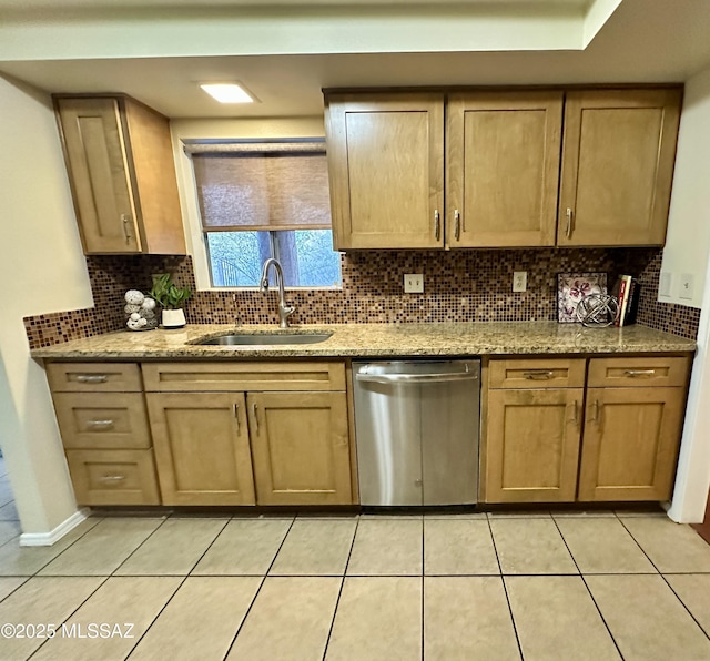 kitchen with light stone countertops, dishwasher, light tile patterned floors, and sink