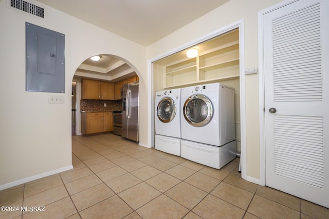 laundry area with electric panel, separate washer and dryer, and light tile patterned floors