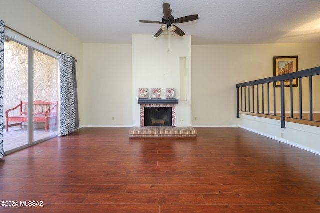 unfurnished living room with dark hardwood / wood-style flooring, ceiling fan, a fireplace, and a textured ceiling