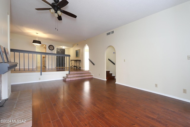 unfurnished living room with a textured ceiling, dark hardwood / wood-style flooring, and ceiling fan