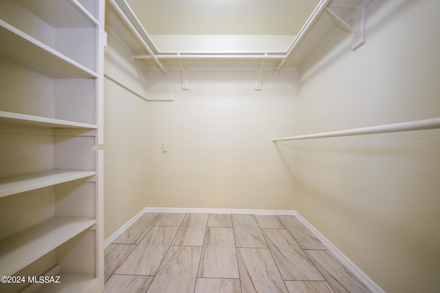 walk in closet with light wood-type flooring