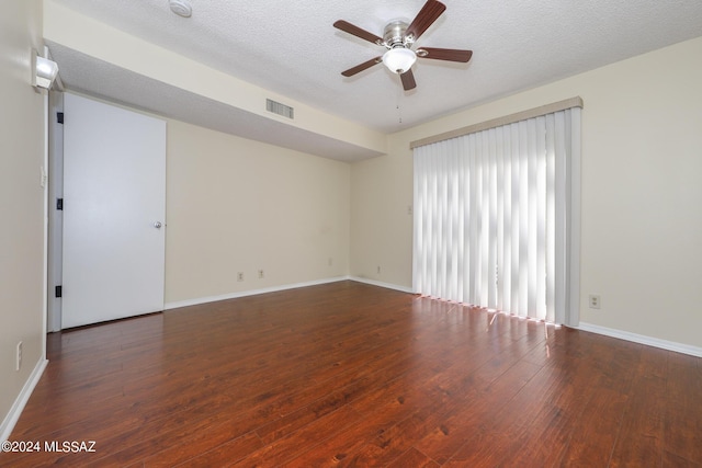 spare room with ceiling fan, dark hardwood / wood-style flooring, and a textured ceiling