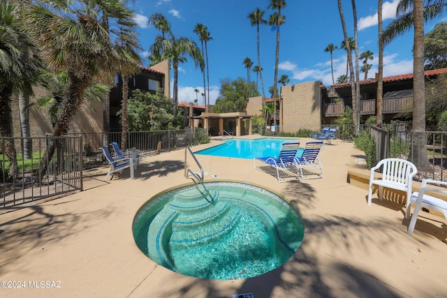 view of pool with a patio area and a community hot tub