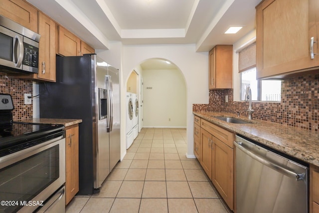 kitchen featuring appliances with stainless steel finishes, tasteful backsplash, light tile patterned floors, and sink