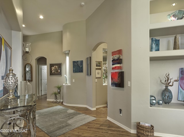 entrance foyer featuring arched walkways, baseboards, wood finished floors, and recessed lighting