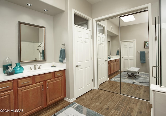 full bathroom featuring baseboards, wood finished floors, and vanity